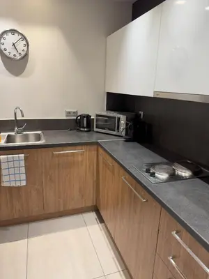 a kitchen with a sink and a clock on the wall at Urban Muse Apartments - Archaeological Museum of Athens in Athens