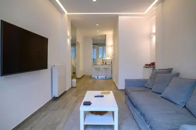 a living room with a blue couch and a white table at Icarus Minimal 2bedroom Bliss in Athens