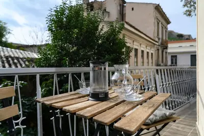 a wooden table with glasses and a blender on a balcony at Icarus Minimal 2bedroom Bliss in Athens