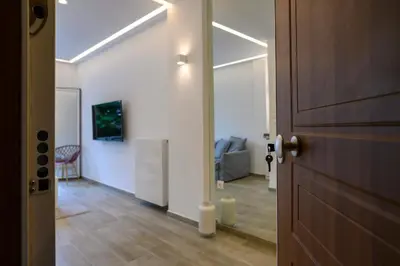 a hallway with a door and a living room at Icarus Minimal 2bedroom Bliss in Athens