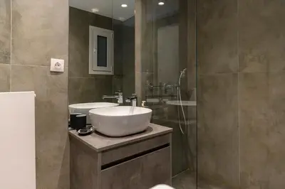 a bathroom with a sink and a shower at Icarus Minimal 2bedroom Bliss in Athens