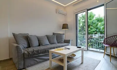 a living room with a couch and a table at Icarus Minimal 2bedroom Bliss in Athens