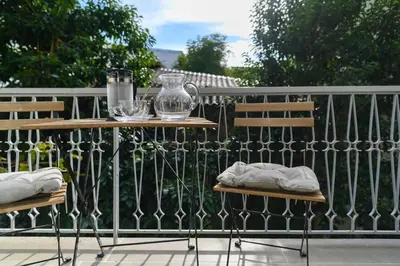 two chairs and a table with a vase on a fence at Icarus Minimal 2bedroom Bliss in Athens