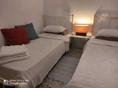 two beds in a room with a lamp on a table at to the sea in Anavissos
