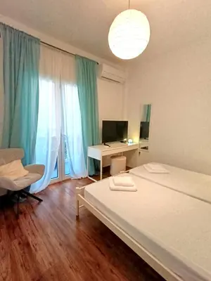 a bedroom with a bed and a desk with a computer at Apartment next to the sea in Anavissos