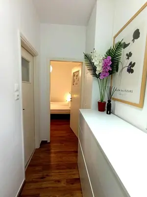 a hallway with a white counter with flowers on it at Apartment next to the sea in Anavissos