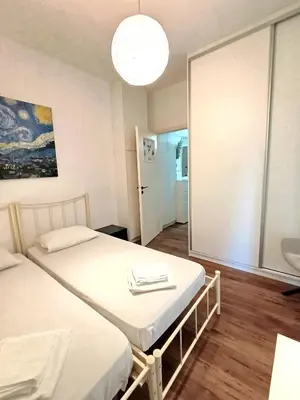 a bedroom with two beds and a mirror at Apartment next to the sea in Anavissos