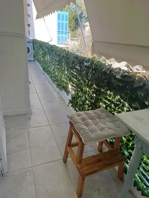 a bench in front of a green hedge at Apartment next to the sea in Anavissos