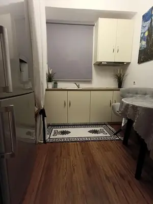 a kitchen with a sink and a table and a counter at Apartment next to the sea in Anavissos