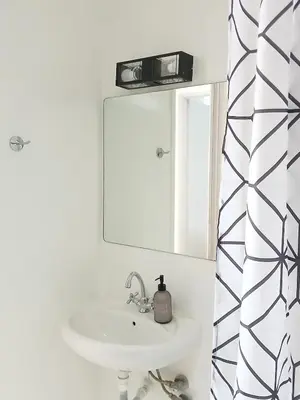 a white bathroom with a sink and a mirror at Σπίτι - Κάστρο πάνω από τη θάλασσα in Piraeus