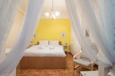 a bedroom with a white bed and a chair at Charming Apartment near Acropolis 100mbps WiFi in Athens