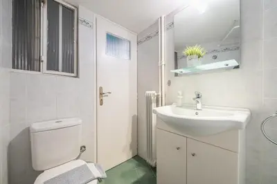 a bathroom with a white toilet and a sink at Charming Apartment near Acropolis 100mbps WiFi in Athens