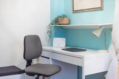 a desk with a chair and a laptop on it at Charming Apartment near Acropolis 100mbps WiFi in Athens