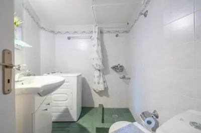 a white bathroom with a sink and a toilet at Charming Apartment near Acropolis 100mbps WiFi in Athens
