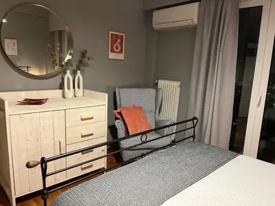a bedroom with a bed and a dresser and a mirror at Acropolis, 2BD Erechthiou 21 23 in Athens
