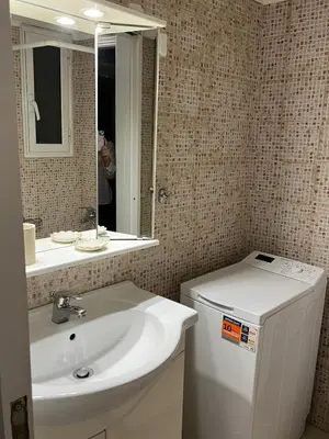 a person taking a picture of a bathroom with a sink and mirror at Acropolis, 2BD Erechthiou 21 23 in Athens