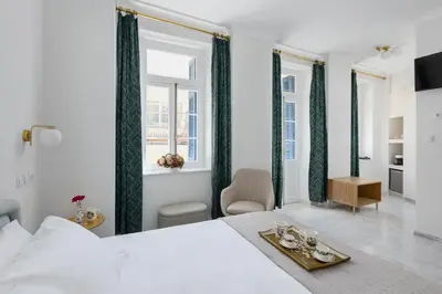 a bedroom with a white bed and green curtains at Florant in Athens