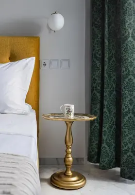 a table with a coffee cup on it next to a bed at Florant in Athens