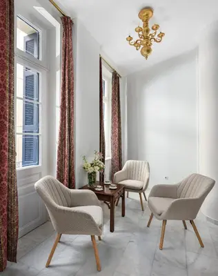 a living room with two chairs and a table and a chandelier at Florant in Athens