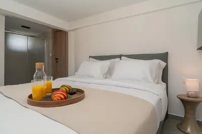 a tray of fruit and juice on a bed at The Minion Elegant Suite - Acropolis View in Athens