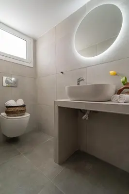 a bathroom with a sink and a toilet and a mirror at The Minion Elegant Suite - Acropolis View in Athens
