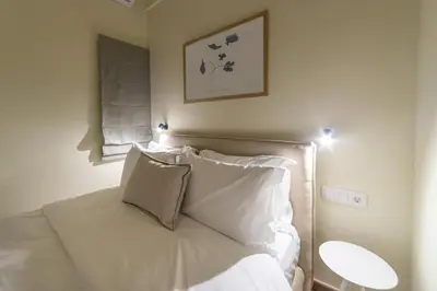 a bedroom with a bed with white sheets and pillows at Home1 in Athens