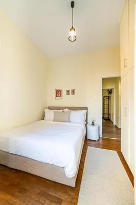 a bedroom with a large white bed and a hallway at Home1 in Athens