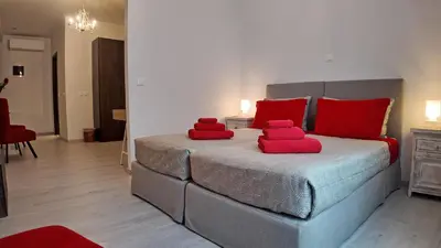 a bedroom with a bed with red pillows on it at Athens Point Hotel Monastiraki in Athens