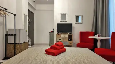 a room with a bed with a red seat at Athens Point Hotel Monastiraki in Athens