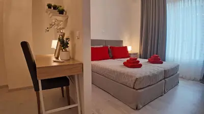 a bedroom with a bed and a desk with red pillows at Athens Point Hotel Monastiraki in Athens