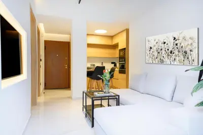 a living room with a white couch and a table at Nidus Boutique Apartment in Athens