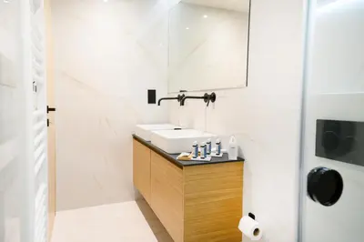 a bathroom with a white sink and a shower at Nidus Boutique Apartment in Athens