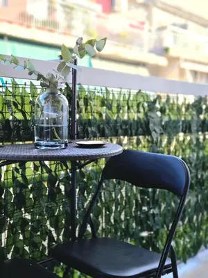 a table with a chair and a glass jar with a plant at Nidus Boutique Apartment in Athens