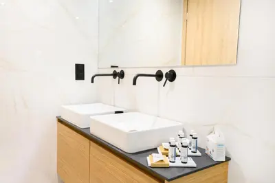a bathroom with a white sink and a mirror at Nidus Boutique Apartment in Athens