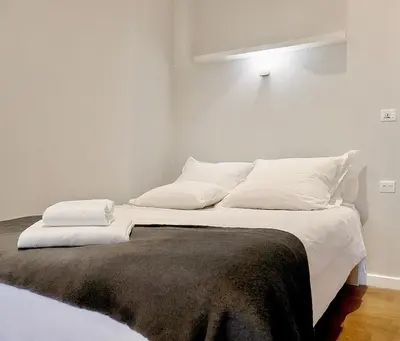 a bed with white sheets and pillows on it at Calliope Suite 4 with Acropolis rooftop access in Athens