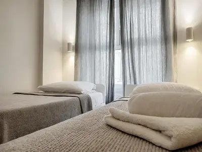 a bedroom with two beds and a window at Calliope Suite 4 with Acropolis rooftop access in Athens