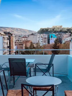 a table and chairs on a balcony with a view at Calliope Suite 4 with Acropolis rooftop access in Athens
