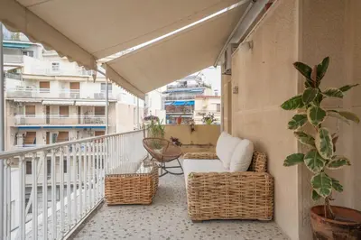 a balcony with a chair and wicker furniture on a building at Maison Terrasse - Georgeous 3Br Apt next to Acropolis in Athens