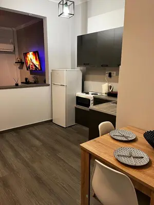 a kitchen with a table and a white refrigerator at Athens comfy apartment in Athens