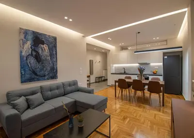 a living room with a couch and a dining room at Vibrant Pagrati 2-BD Retreat with Elegant-Modern style in Athens