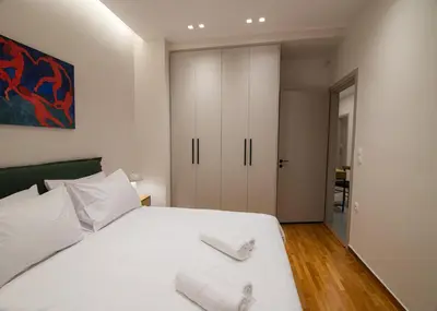 a bedroom with a white bed with two towels on it at Vibrant Pagrati 2-BD Retreat with Elegant-Modern style in Athens