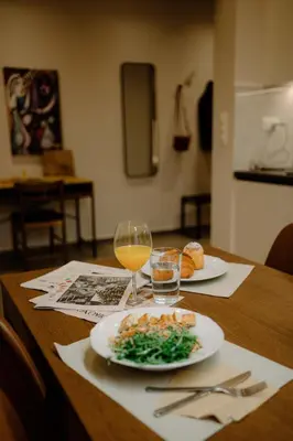 a table with a plate of food and a glass of wine at Vibrant Pagrati 2-BD Retreat with Elegant-Modern style in Athens