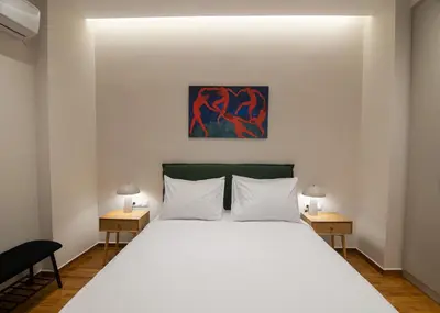 a bedroom with a large white bed with two tables at Vibrant Pagrati 2-BD Retreat with Elegant-Modern style in Athens