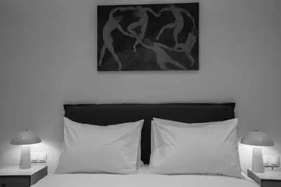 a bedroom with a bed with white pillows and two lamps at Vibrant Pagrati 2-BD Retreat with Elegant-Modern style in Athens