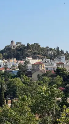 a group of houses on a hill with trees at The Green Parthenon in Athens