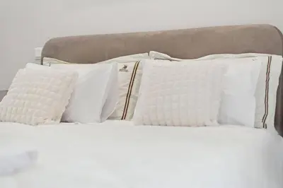 a pile of pillows sitting on top of a bed at Athene Appartment in Athens