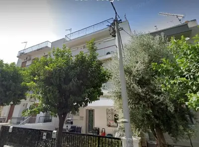 a white building with trees in front of it at Seaside Resort in Piraeus