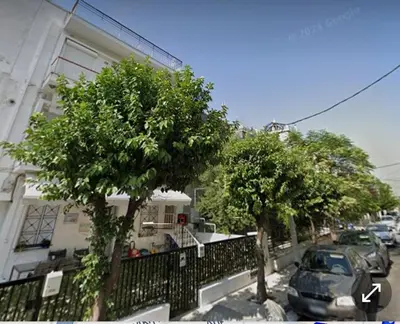 a street with trees in front of a building at Seaside Resort in Piraeus