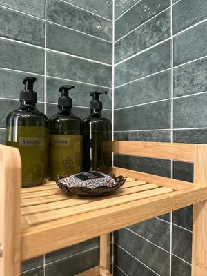 three bottles of detergent sitting on a wooden shelf at Glyfada Center Front Seaview Studio A in Athens