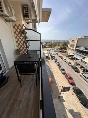 a balcony with a black table and a parking lot at Glyfada Center Front Seaview Studio A in Athens
